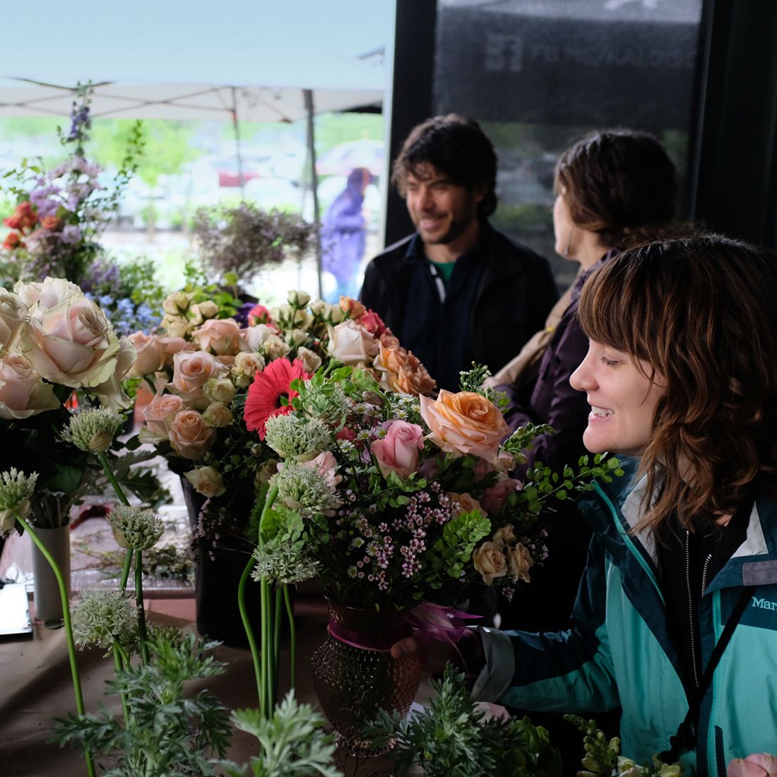 shoppers looking at flowers at pop-up market