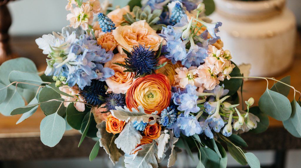close up of bridal bouquet in oranges and pale blues