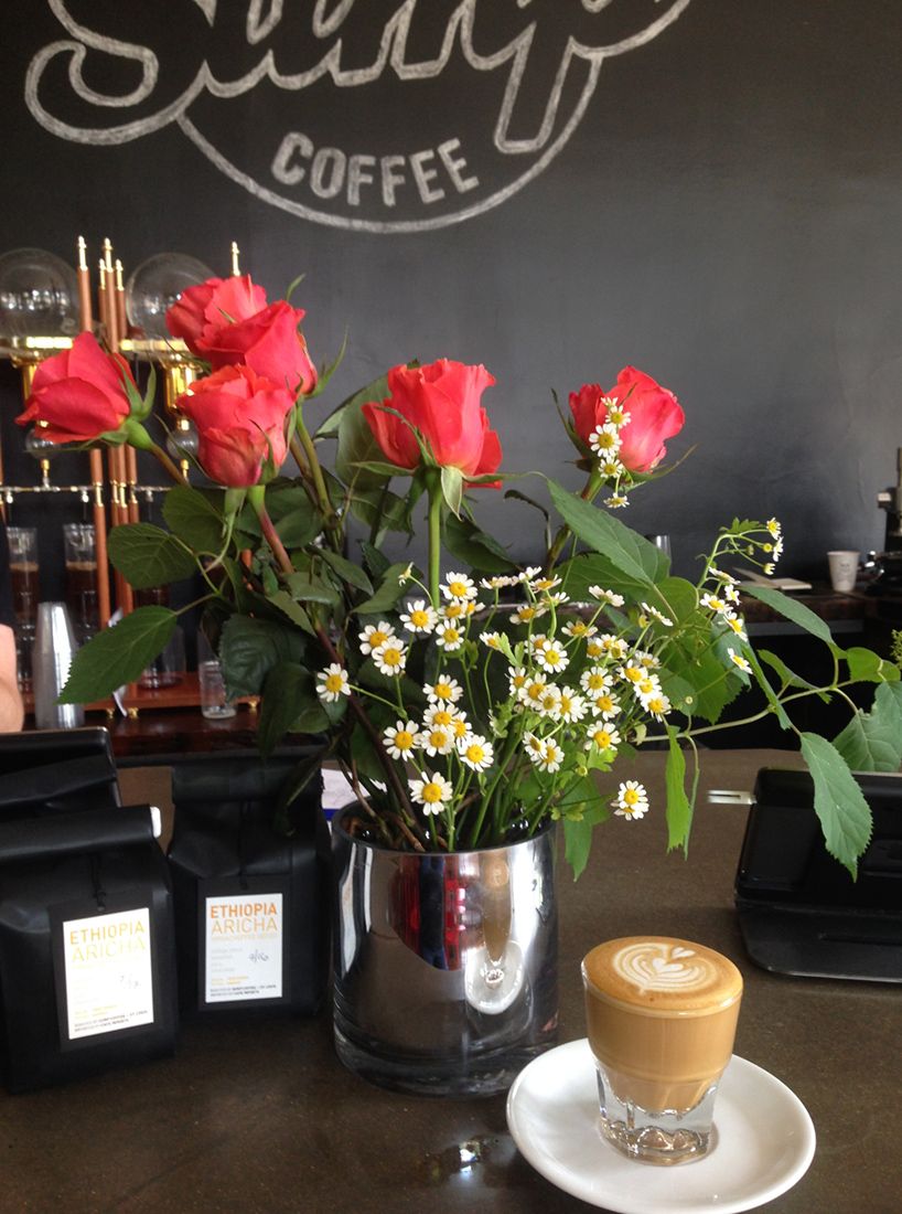 arrangement of roses on the counter in a coffee shop